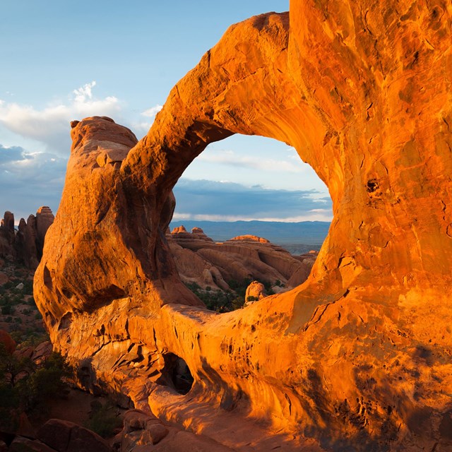 A broad, red rock arch