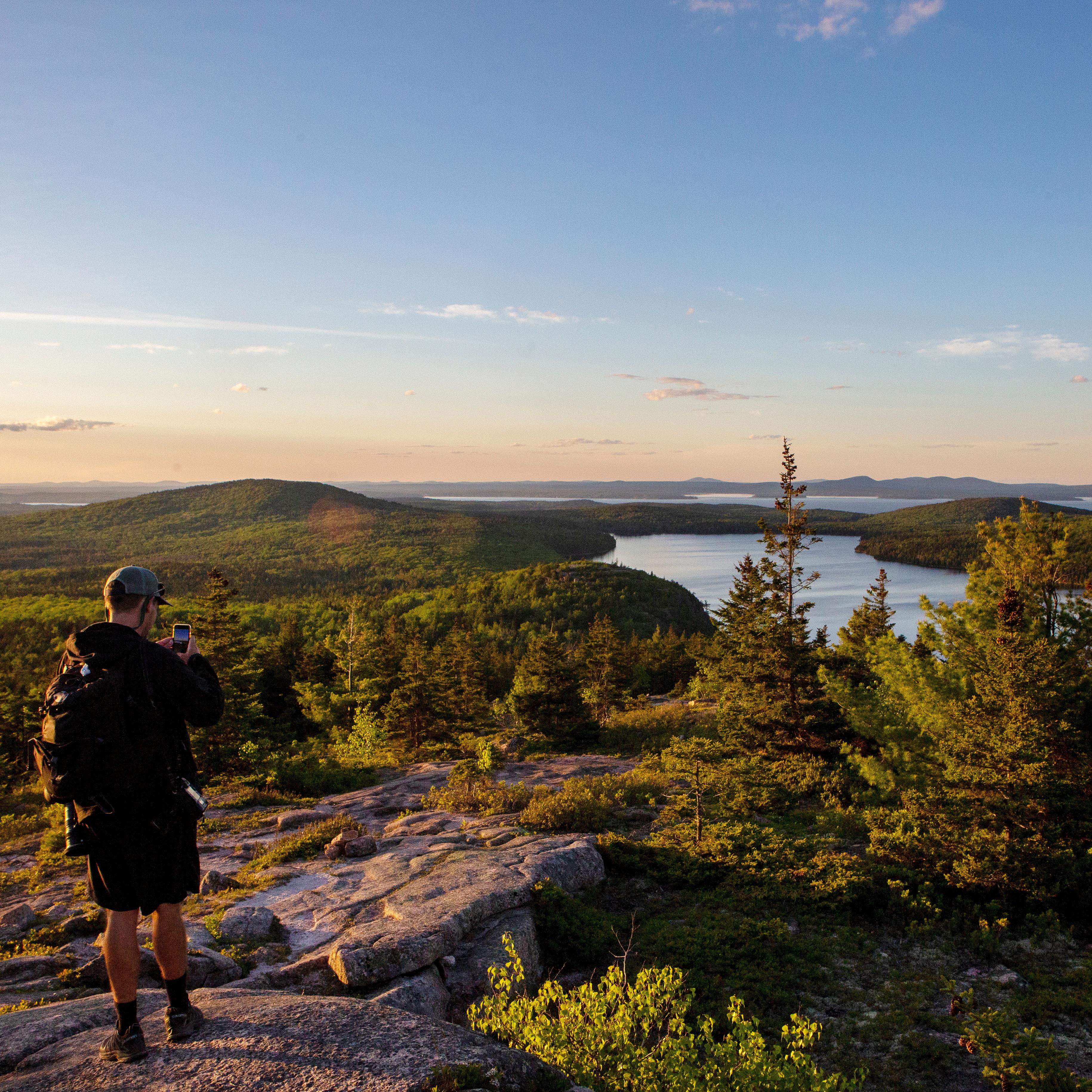 Visitors photographs a sunset over a lake