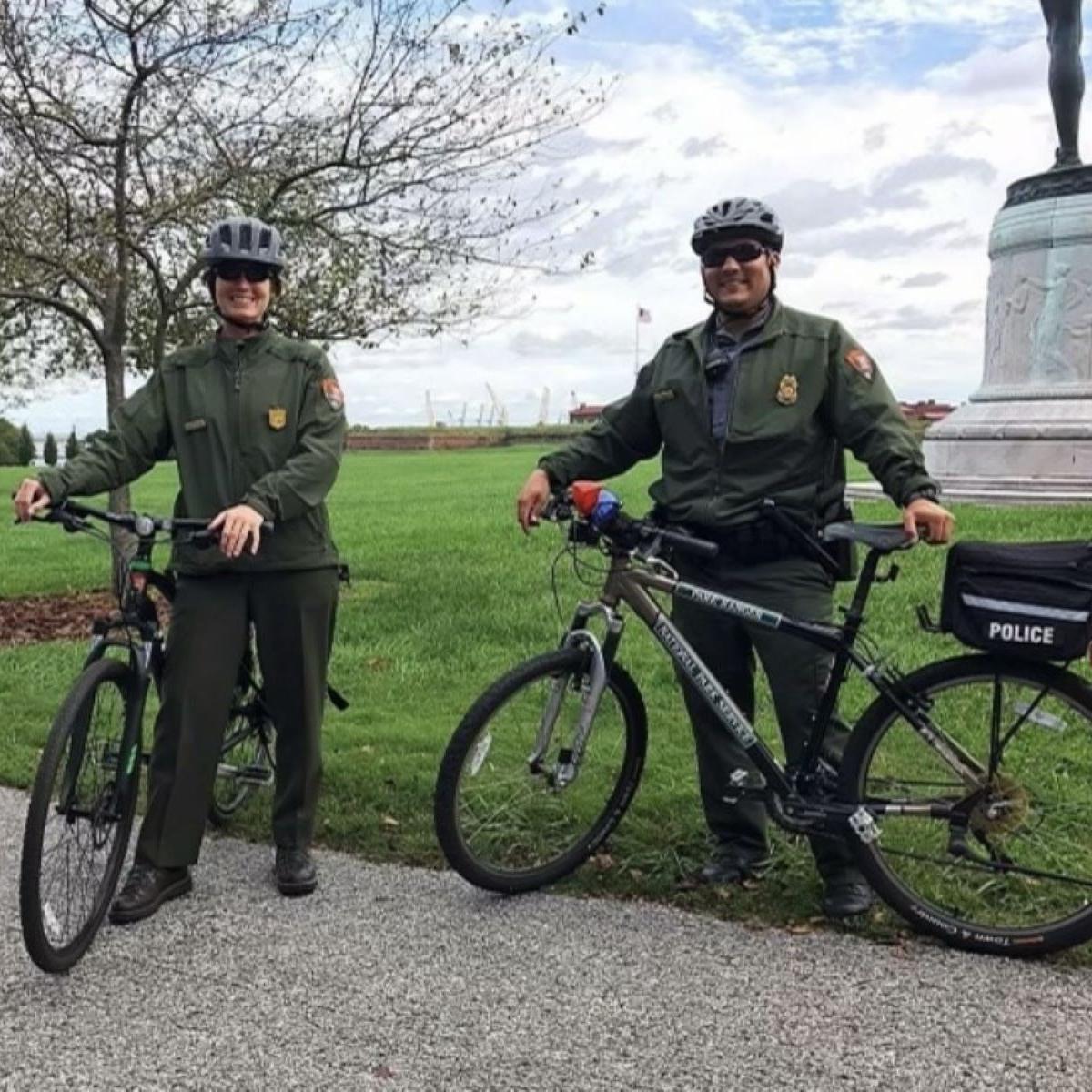 Two rangers on bikes with helmets on.