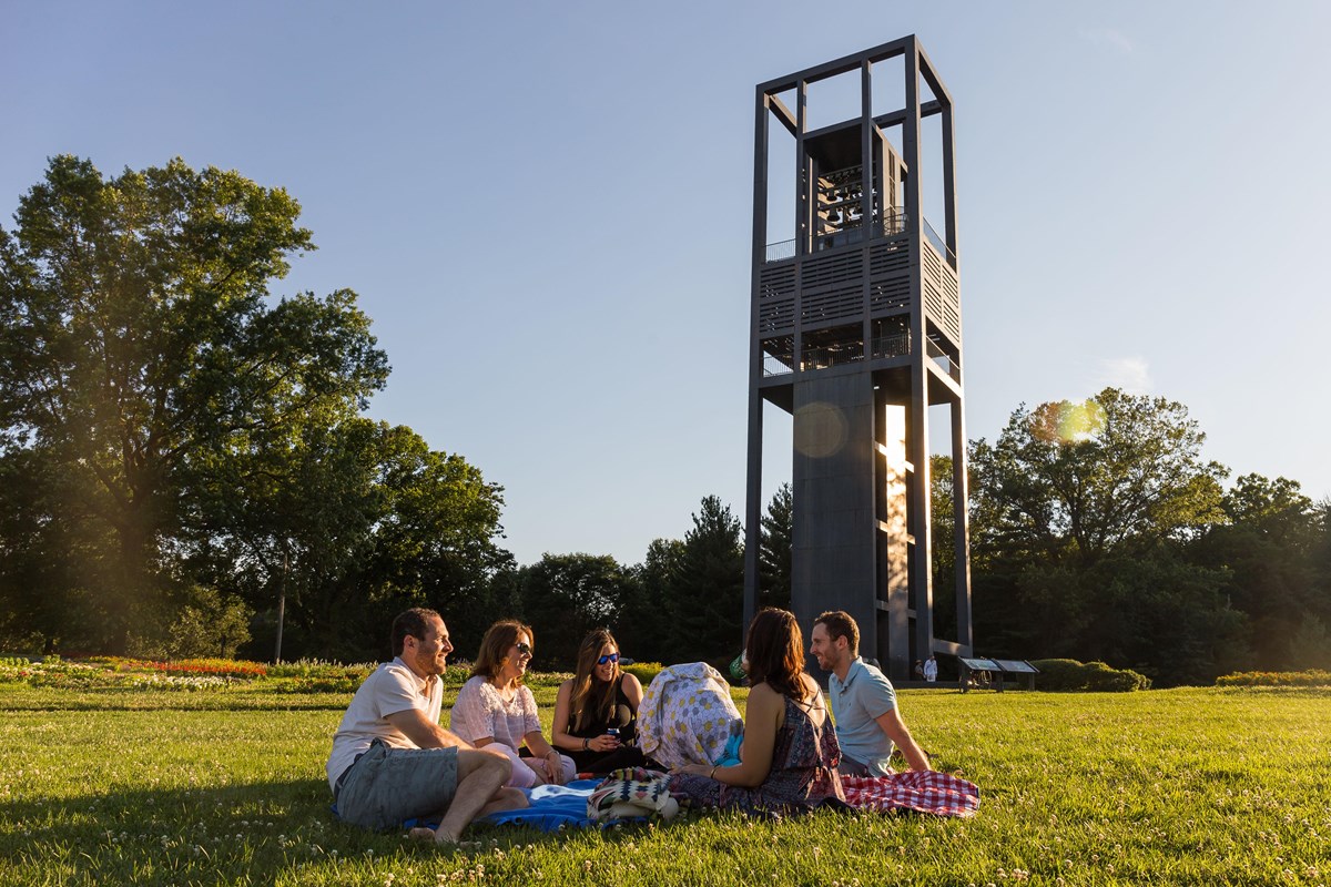 Visitors sitting under the Netherlands Carillon listen to the bells.