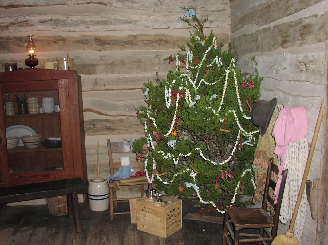 A Christmas tree decorated with popcorn strings stands in the corner of the Johnson log cabin.