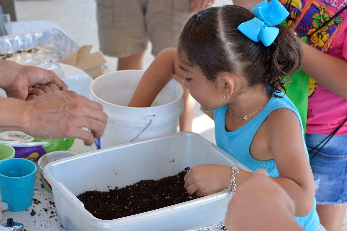 Child makes a seedball with Park Rangers at San Antonio Missions National Historical Park