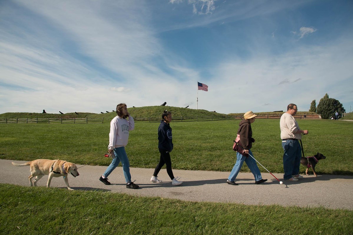 Visitors walking dogs in front of the fort.