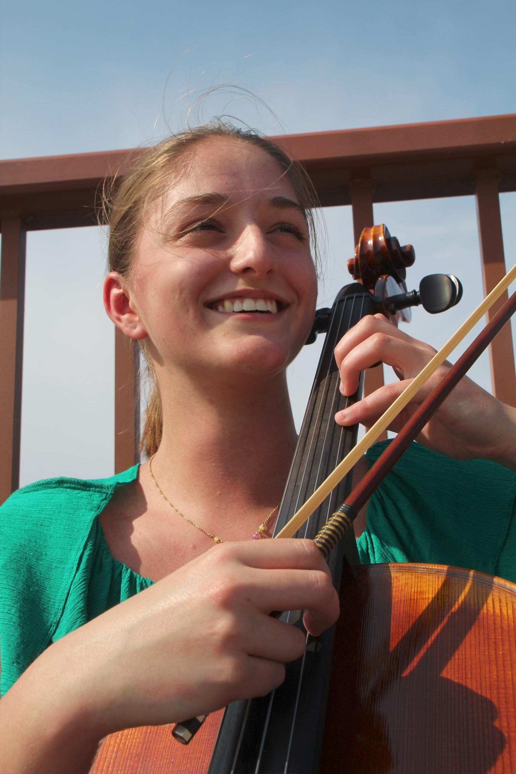 Woman outdoors holding a cello
