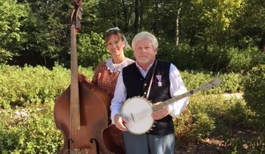 Picture of a man and woman in period dress holding musical instruments