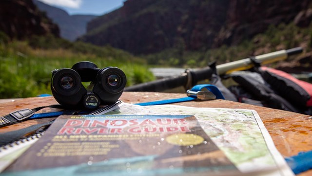 set of binoculars resting on a river guide book