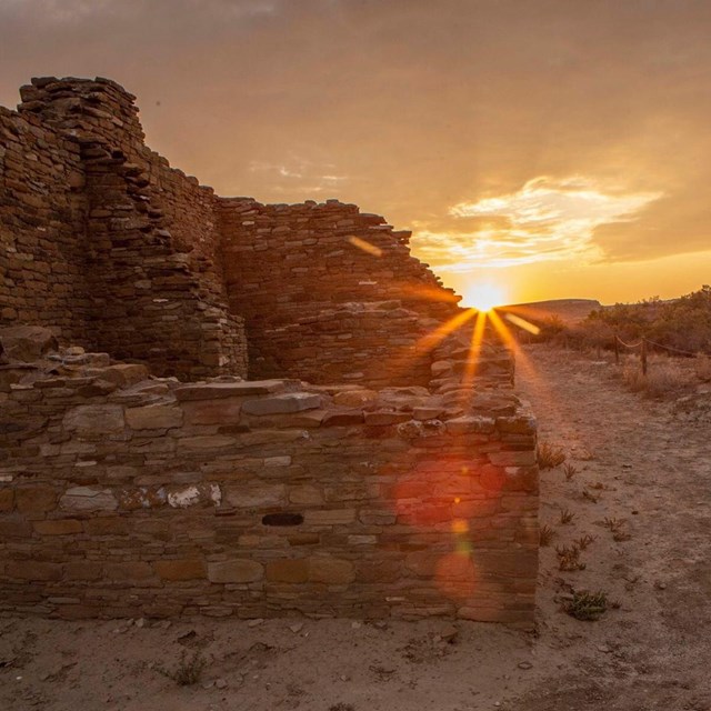 The sun peaks around a cultural building.