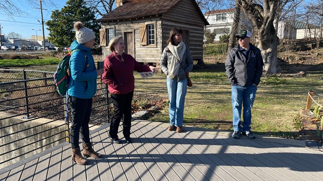 A group of people stand outside in conversation.