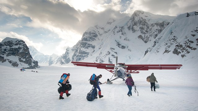 A group loads gear onto a commercial plane in Denali National Park and Preserve.