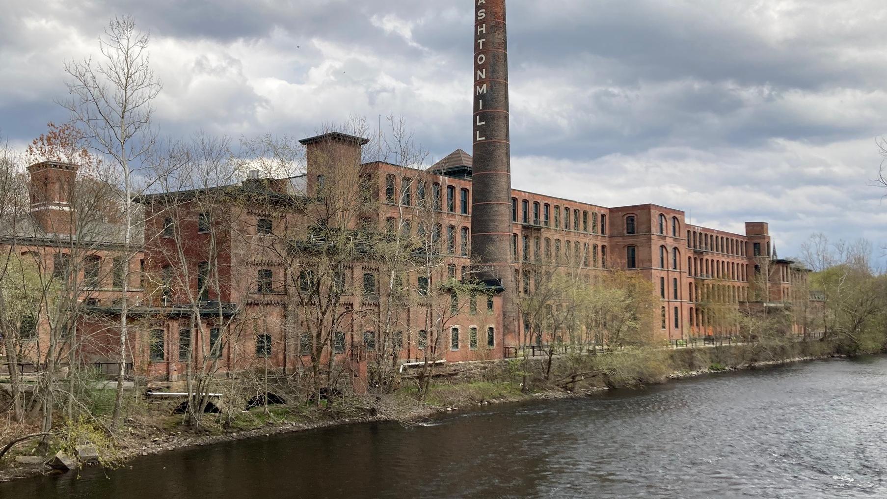 The historic Ashton Mill along a river. 