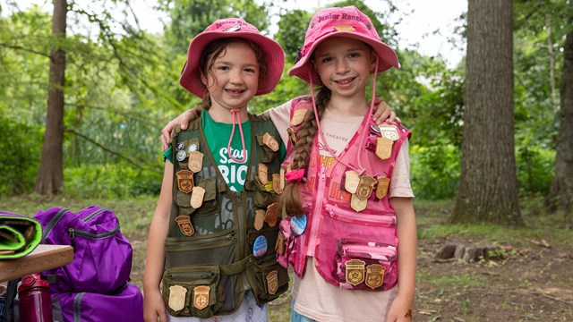 Two Junior Rangers display their Junior Ranger badge collections at Kenilworth Aquatic Gardens