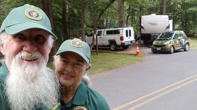 Two people standing by a campground.