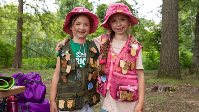 Two Junior Rangers display their Junior Ranger badge collections at Kenilworth Aquatic Gardens.