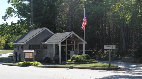 A ranger station with a flag pole and driveways leading up to it