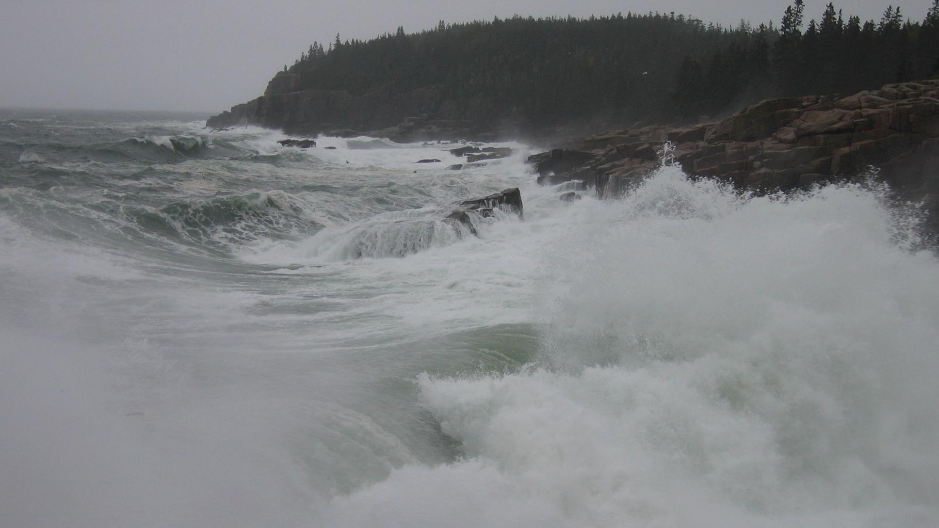 strong waves crash against the rocks during a storm