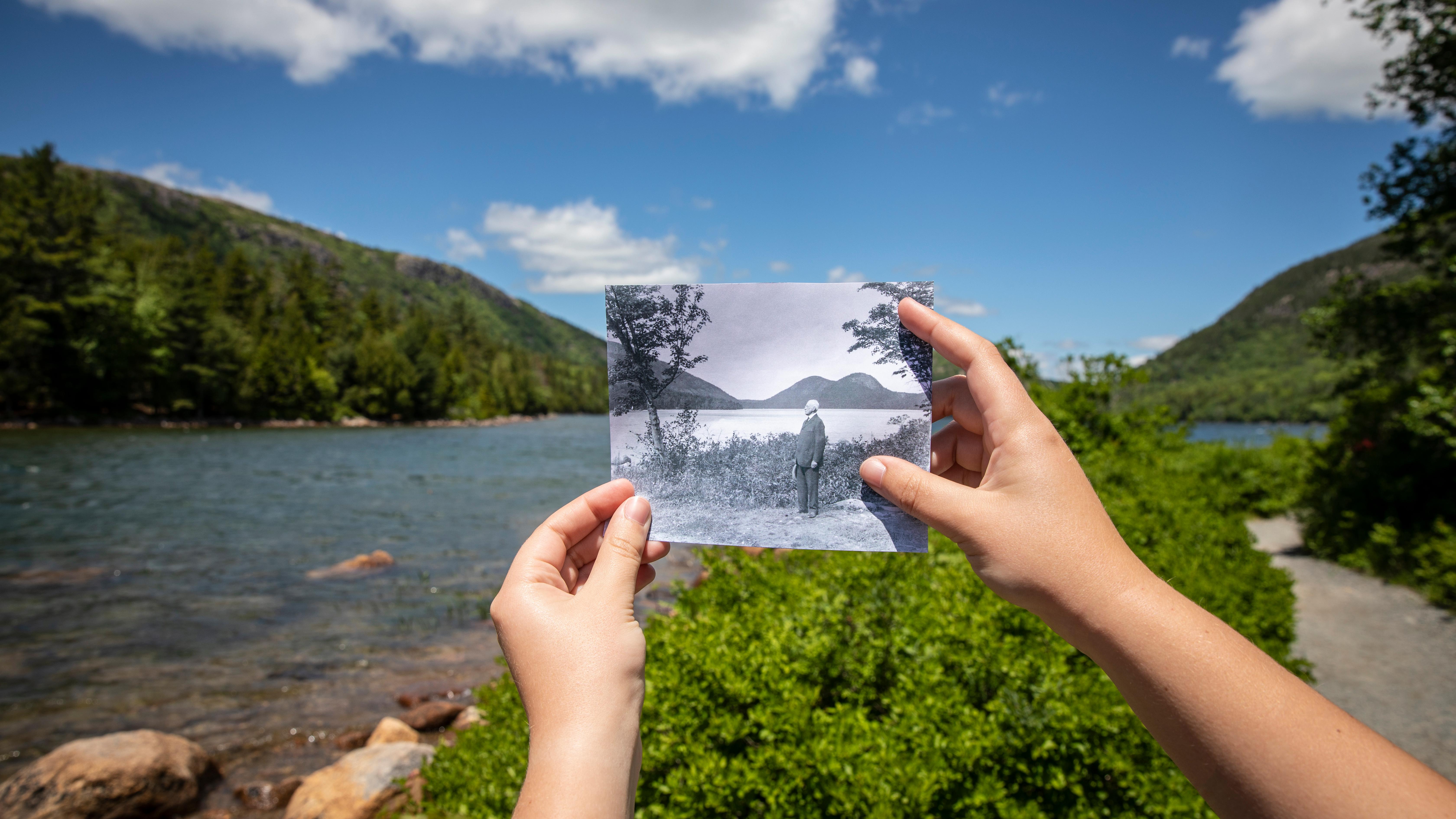 Historic photograph held in front of a landscape