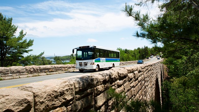Bus and cars driving over a stone bridge
