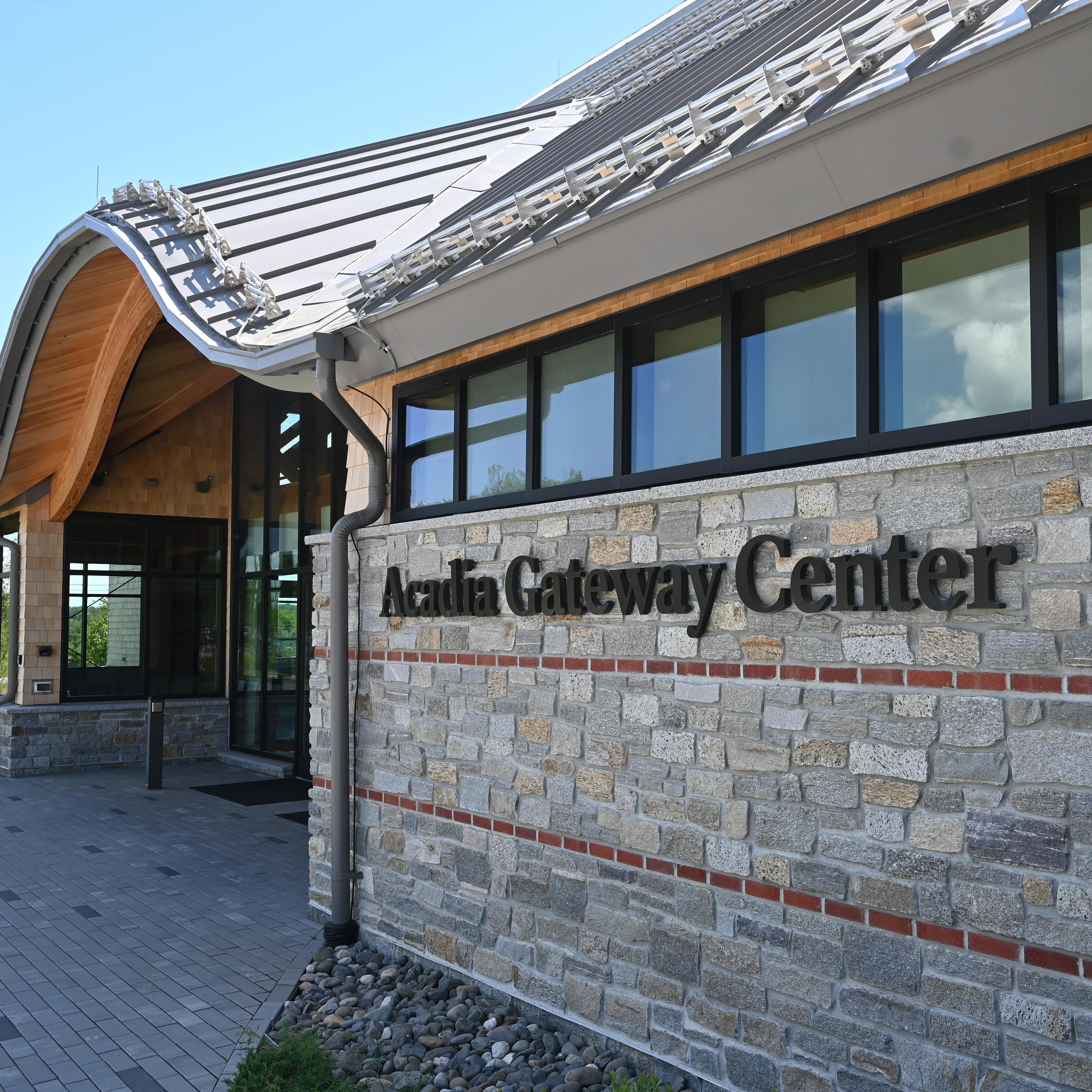 A stone building entrance with a sign that says Acadia Gateway Center