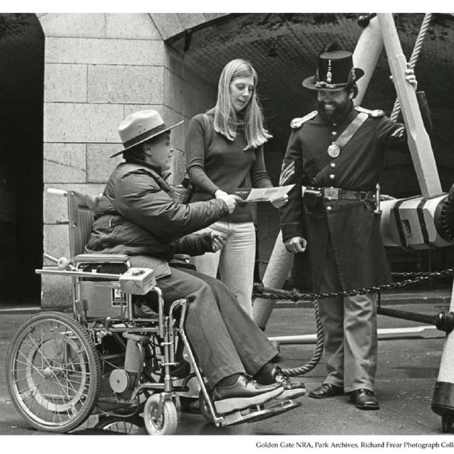 Woman in wheelchair chatting with two others Golden Gate, circa 1980