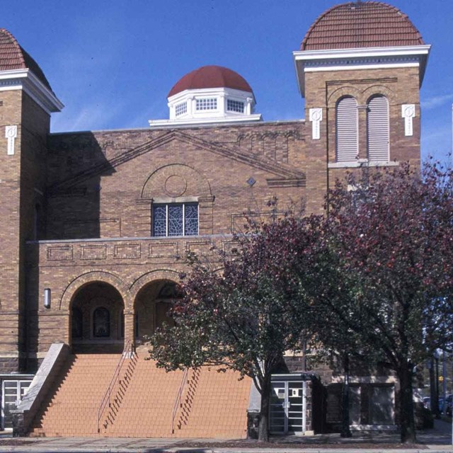 Color photo of brick church with two spires