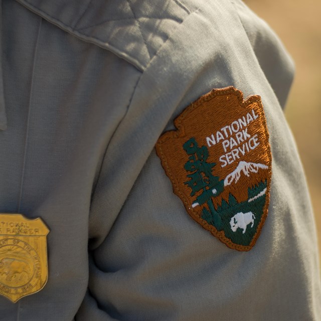 a NPS badge and patch on a ranger uniform
