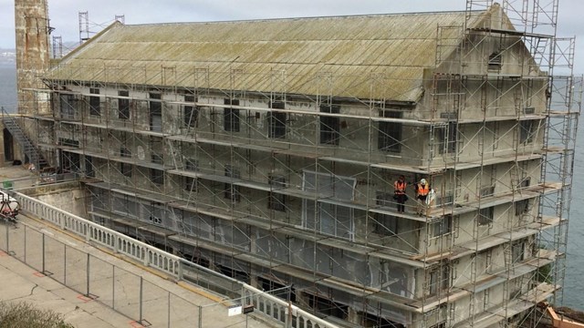 Four story building with scaffolding it all around.