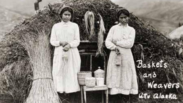 a historic scene of two women standing outside a sod house with fine grass baskets.