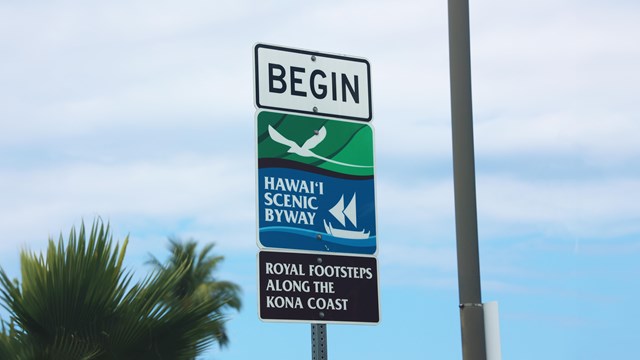 Close-up of road sign that reads "Royal Footsteps along the Kona Coast"