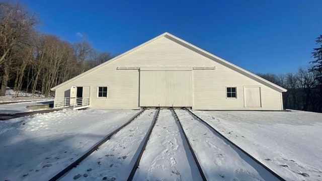 Engine House building with railroad tracks in the snow.