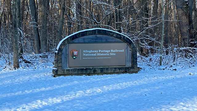 The park entrance sign with snow.