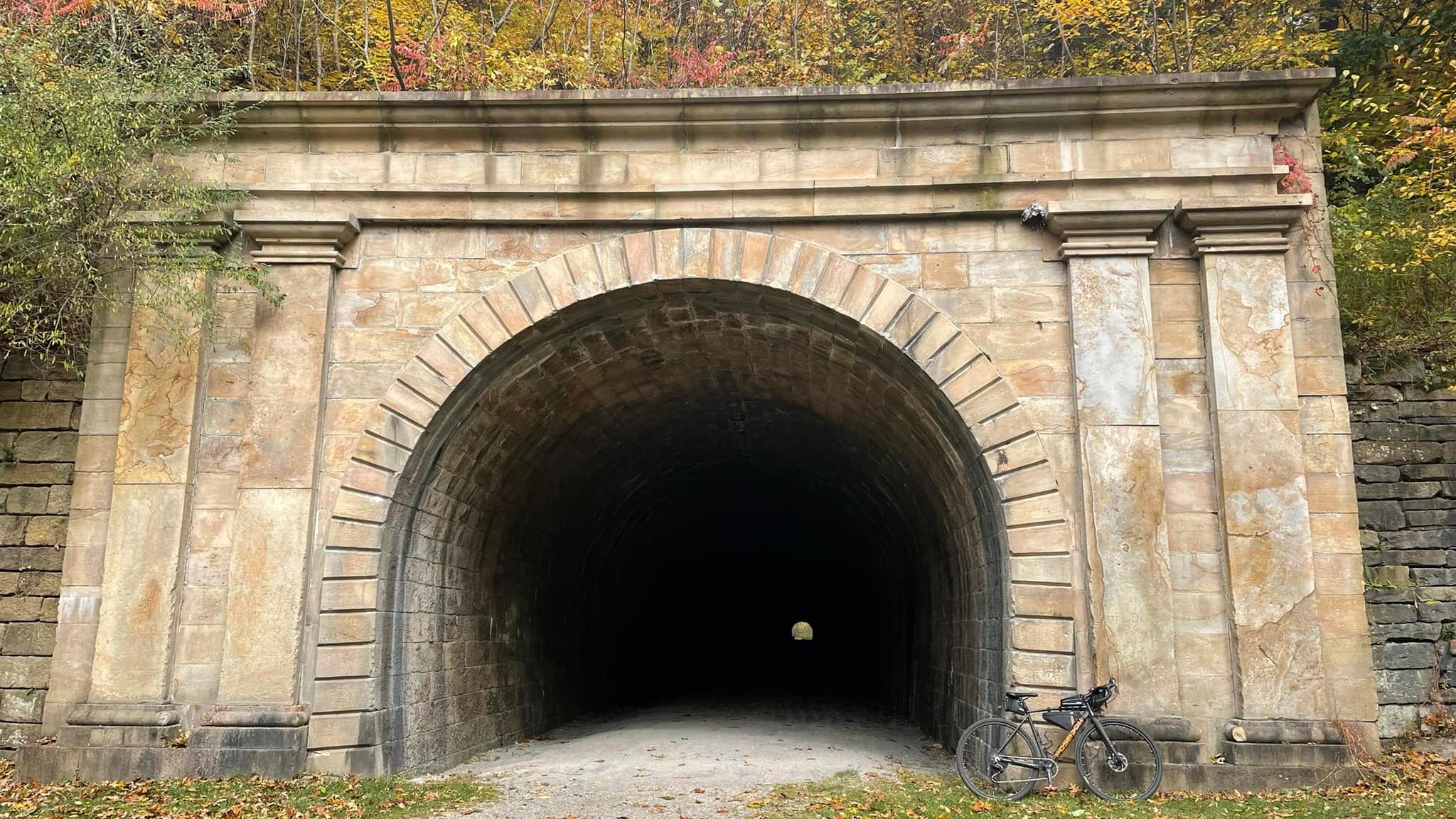 A railroad tunnel made out of stone.