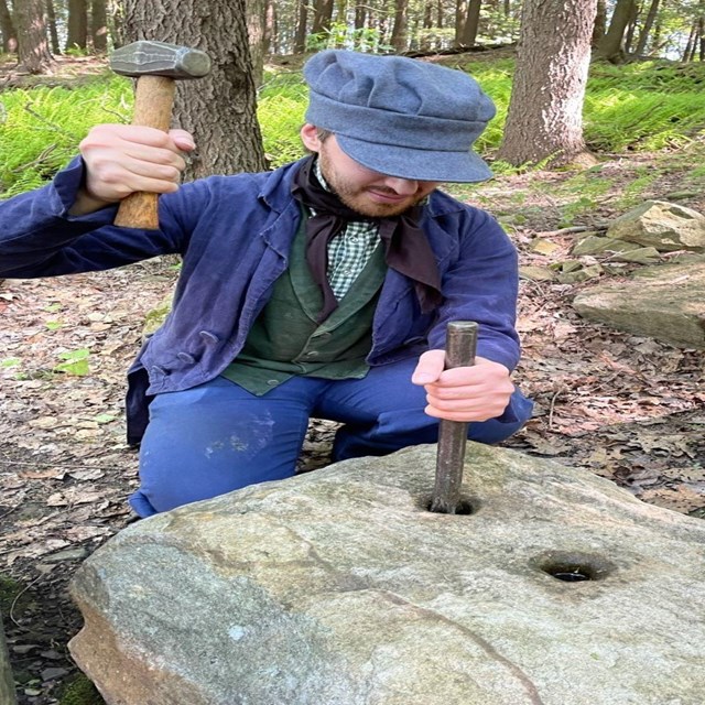 A ranger in period clothing doing a stone cutting demonstration.