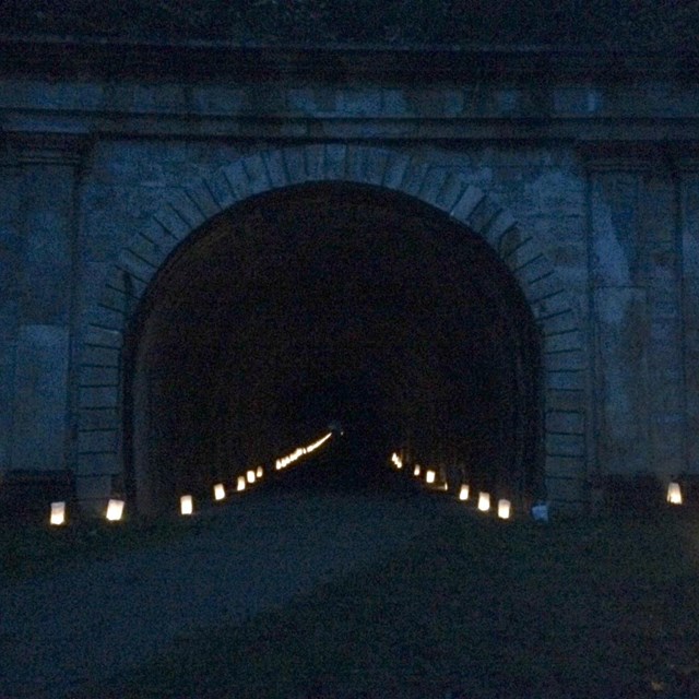 Railroad tunnel at night with luminaries. 