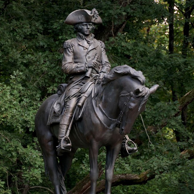 Monument of General Nathaniel Greene in a tri-cornered hat mounted on a horse.