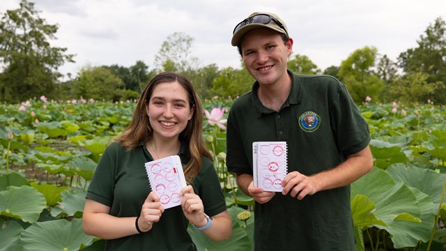 Two National Park Service interns show their passport stamp collection at Kenilworth Aquatic Gardens