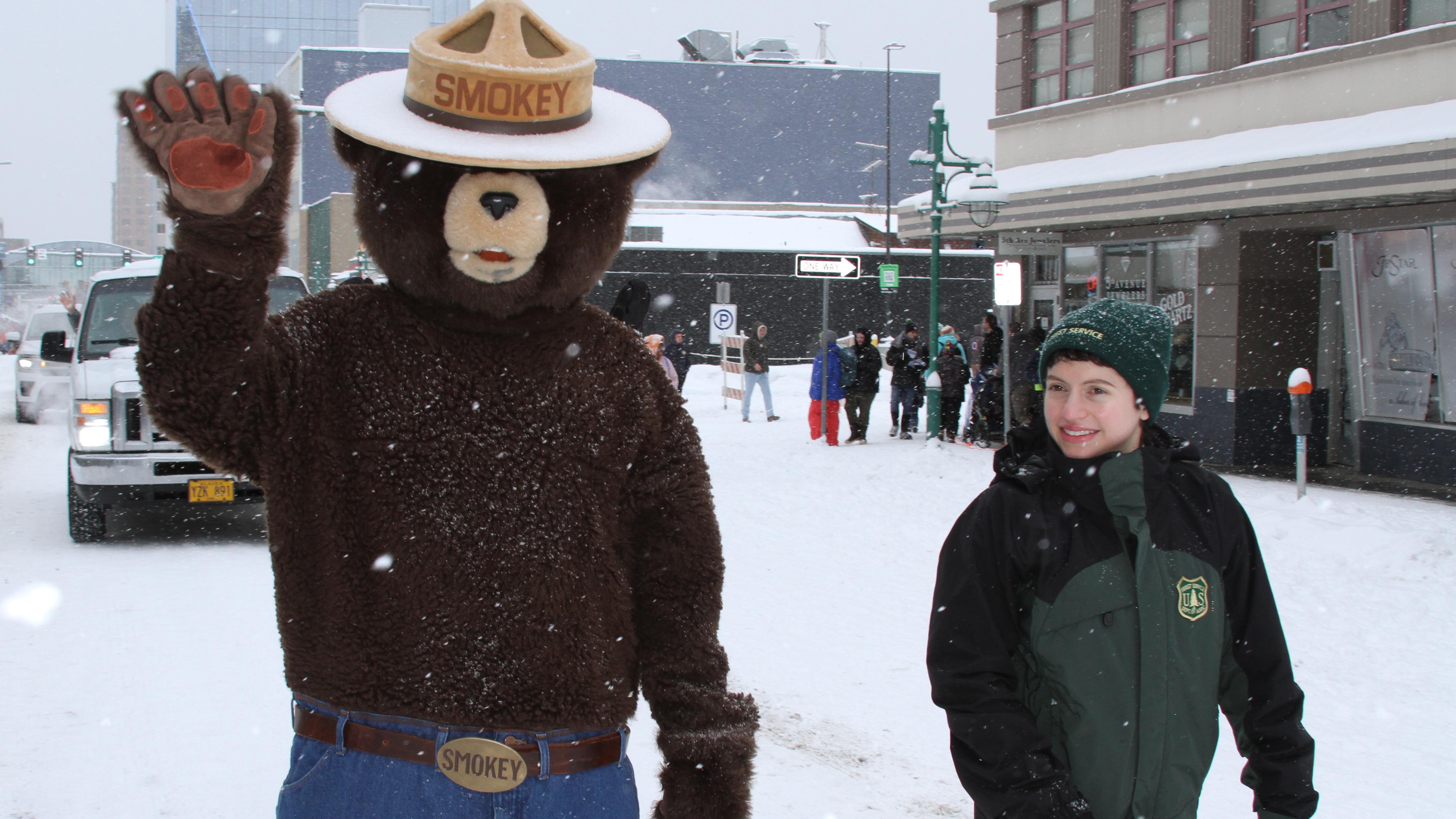 Smokey Bear and Forest Ranger walking in snow. 