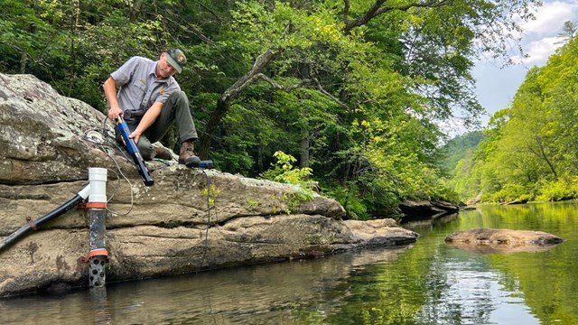 NPS staff servicing a water quality sonde on the river.