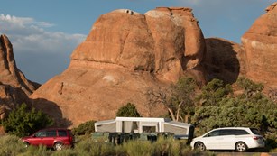 a pop-up camper with red rocks in the background