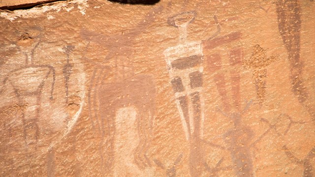 human shaped figures painted onto a rock wall
