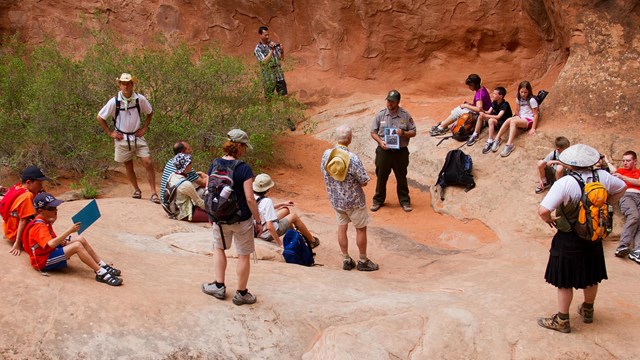 a group of people in surrounded by red rock walls
