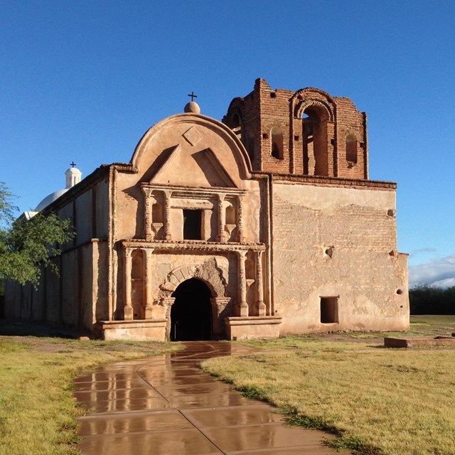 Tan church with blue sky and grass