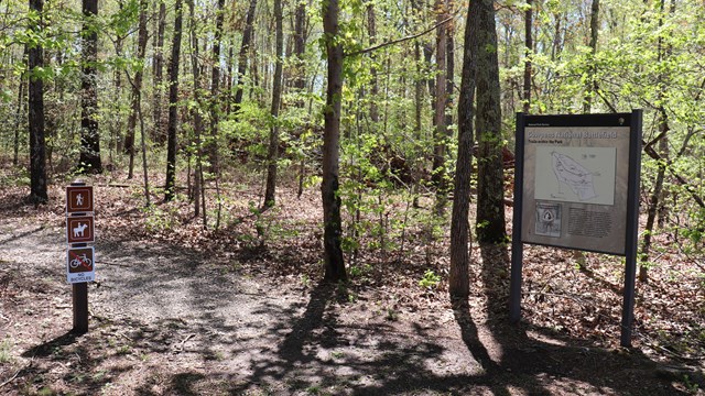 Entrance to nature trail with wayside display and trail signs