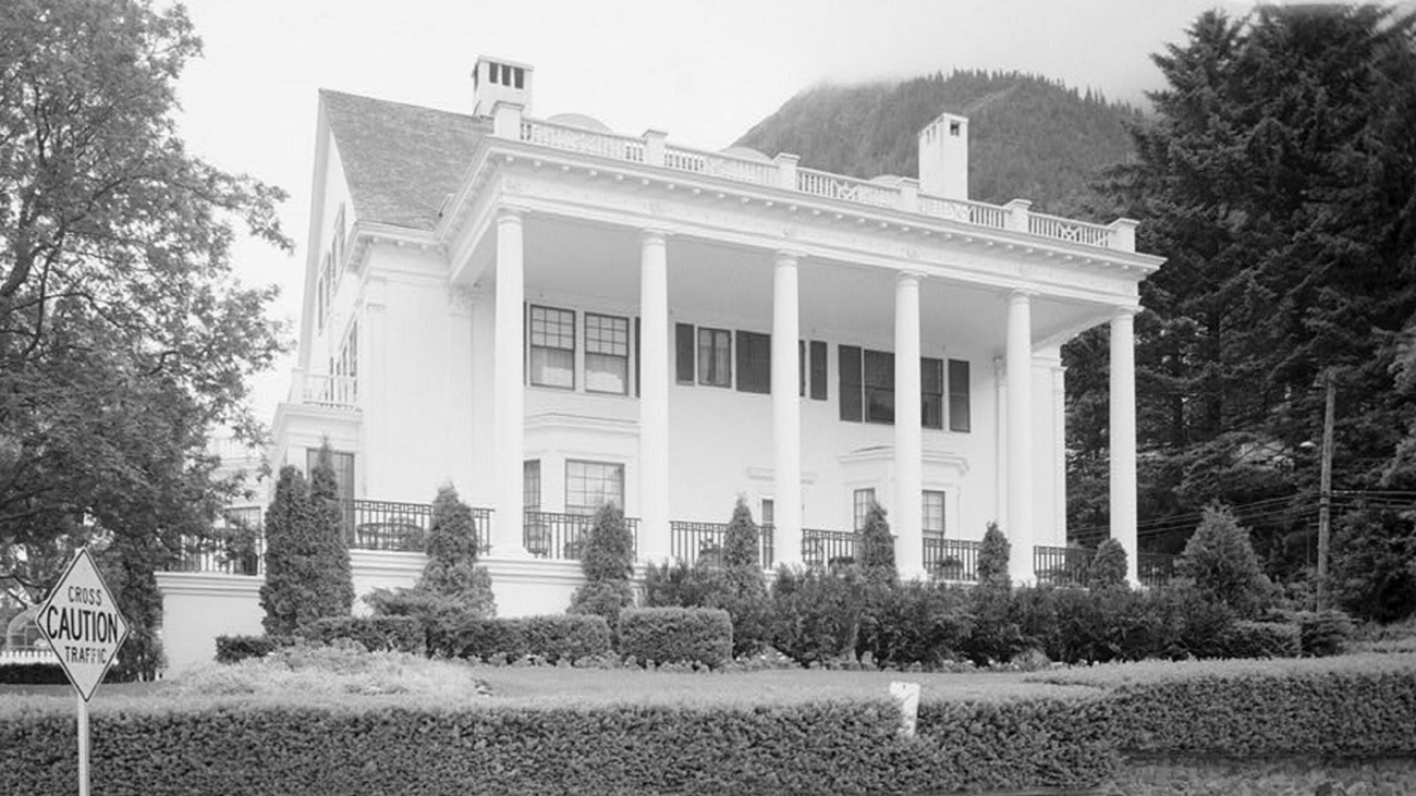 Black and white photo of the front of governor's mansion with large white pillars. Lib of Cong. CC0 