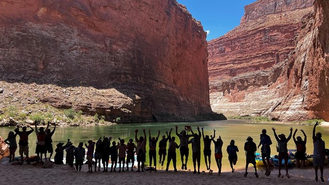 Silhouette of a group of people on a beach along the river in the Grand Canyon