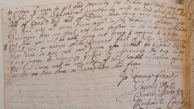 black ink handwriting on paper attached to a page of a book