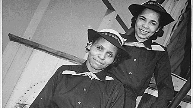 Two African American women in military uniforms stand on a narrow set of stairs
