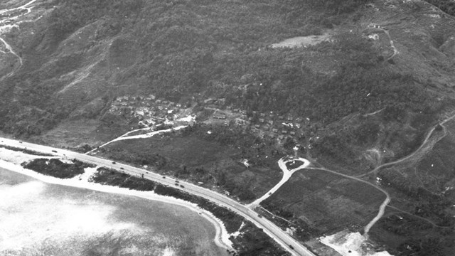 Ariel view of a small village tucked up against the side of a tall hill