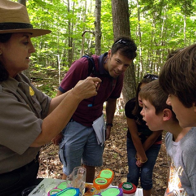 Ranger showing kids and adult tiny aquatic life