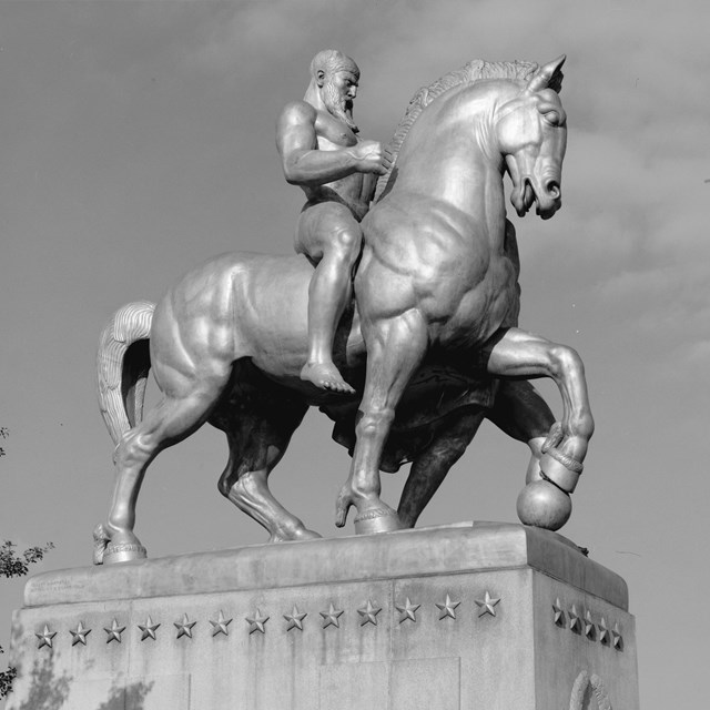 Black and white photograph of a statue of a man riding a horse