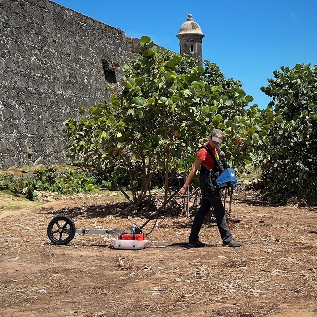 Archeologist wearing and pulling ground monitoring equipment